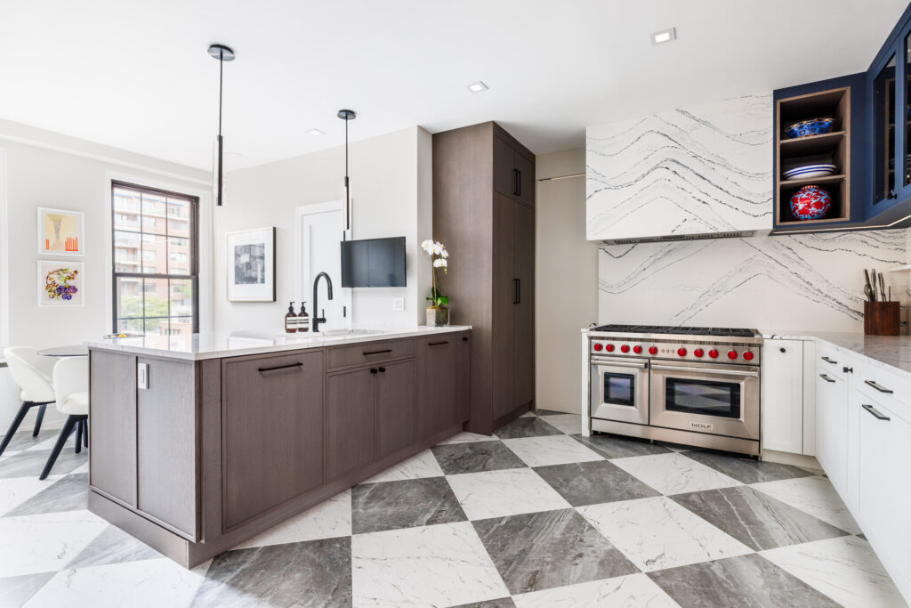 Modern kitchen with large island, wood cabinetry, black fixtures, and checkered marble tile flooring