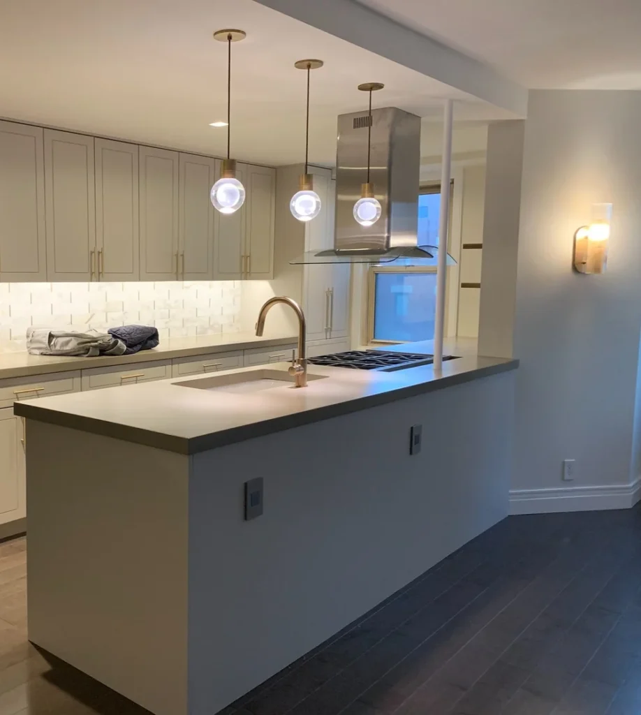 Open-concept NYC kitchen design with a spacious island, modern brass fixtures, and statement pendant lights that elevate the sophisticated yet functional layout.