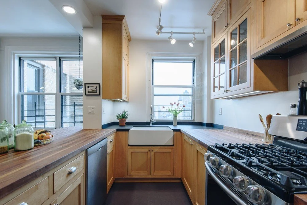 Bright Manhattan kitchen remodel with warm wood finishes, clean-lined cabinetry, and contemporary lighting for a fresh, urban feel.