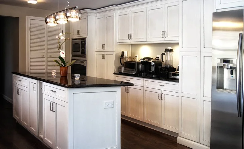 Open-concept kitchen featuring glass-front cabinetry, expansive counters, and a central island illuminated by statement pendant lighting.