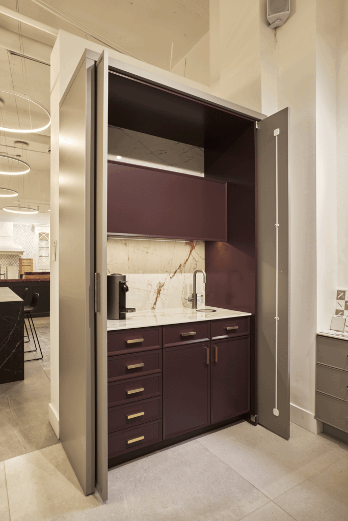 Cabinets : Plain and Fancy Purple Cabinets : Royal Heights Door Style : Chatham Outside : Cobblestone Door Style : Brookside Countertop and Backsplash : Dekton Color Name : Awake Pulls : Rejuvenation Faucet : Zip Water Faucet Color : Gunmetal Pocket Door Hardware : HAWA Lighting : Hafele